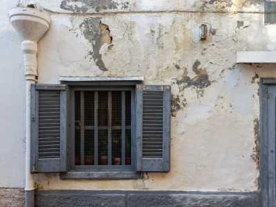 ...interrotta da una porta azzurra a vetri cui fa pendant una persiana di egual colore. � il laboratorio dell�87enne falegname Pinuccio Volpe, che troviamo per� chiuso al nostro arrivo 